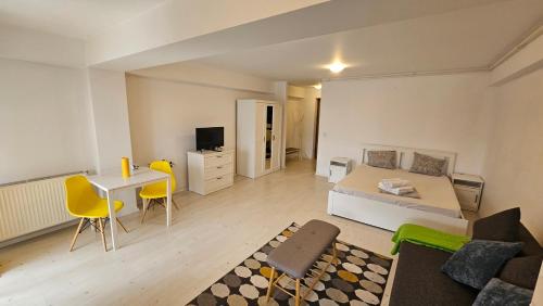 a bedroom with a bed and a desk and a table at Airport Residence in Otopeni