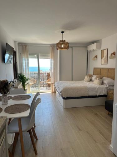 a bedroom with a bed and a table and a dining room at Apartamento JÚPITER Vistas in Benalmádena