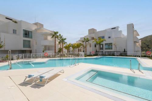 a swimming pool in front of a building at Increíble apartamento 402 en Palo Alto in Ojén