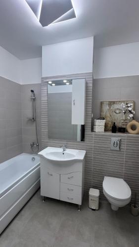 a bathroom with a sink and a tub and a toilet at David Apartament in Buzău
