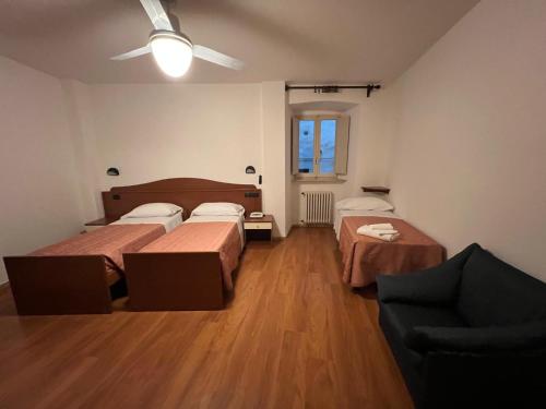 a room with two beds and a couch at Hotel Roma Assisi in Assisi