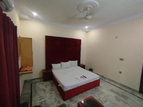 a bedroom with a bed in a room at Hotel Crown Plaza, Near Karachi Airport, Darul sehat Hospital, Dow, Agha khan and Liaqat Hospital in Karachi