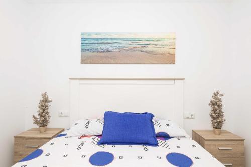 a bedroom with a bed and a painting on the wall at Apartamento Tom-Isi in Rota