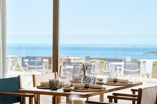a table with glasses and napkins and a view of the beach at Iberostar Selection Es Trenc -New Opening- in Colonia Sant Jordi