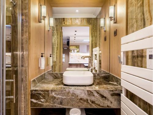 La salle de bains est pourvue d'un grand lavabo en marbre. dans l'établissement Merveil - Signature Suite - Tour Eiffel - Viala IV, à Paris