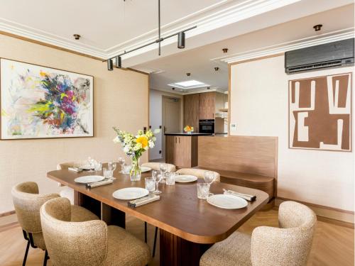 une salle à manger avec une table et des chaises en bois dans l'établissement Merveil - Signature Suite - Tour Eiffel - Viala IV, à Paris