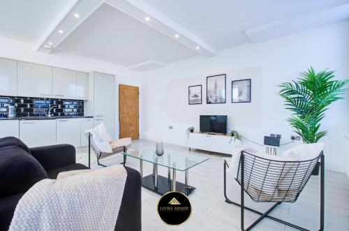 a living room with a couch and a tv at Stylish 1 bed Apt By Livra Estate Short Lets & Serviced Accommodation Sutton With Free Parking in Sutton