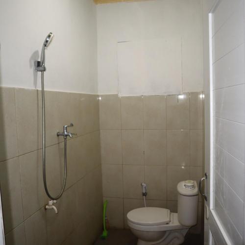 een kleine badkamer met toilet en douche bij SHYA House in Batukaras