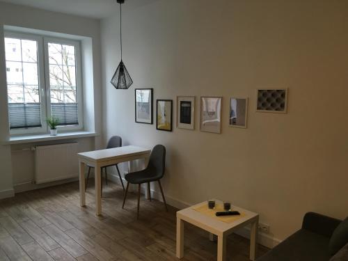 een woonkamer met een tafel en 2 stoelen bij APARTAMENTY DŁUGI TARG in Gdańsk