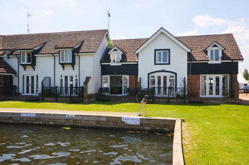 a house with a pond in front of it at Marchesi in Wroxham