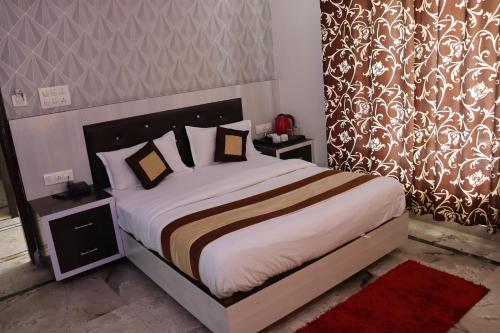 a bedroom with a bed with white sheets and pillows at Pink Park by Panache Hotels in Bīr