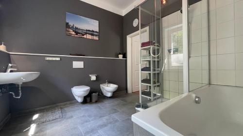 a bathroom with a tub and a toilet and a sink at MK Altstadt Apartment in Erfurt
