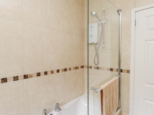 a bathroom with a shower and a tub and a sink at 3 Glyn Y Mor in Pwllheli