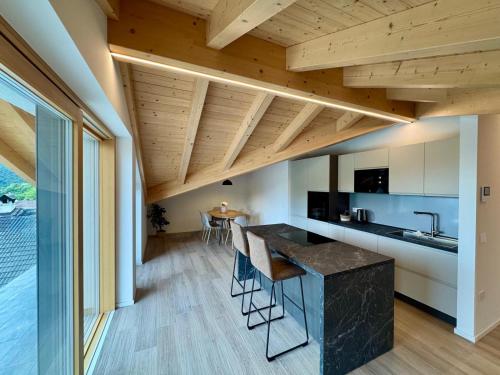 an open kitchen and dining room with wooden ceilings at Mountain Lodge in San Lorenzo in Banale