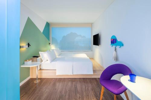 a living room with a white couch and a purple chair at Tru by Hilton Ha Long Hon Gai Centre in Ha Long