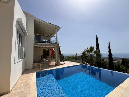a villa with a swimming pool next to a house at Villa Daria Kamares Tala Luxury Sea View in Paphos