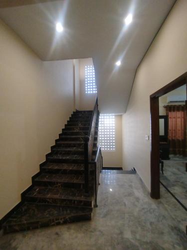 a staircase in an empty room with a stair case at Hotel Crown Plaza, Near Karachi Airport, Darul sehat Hospital, Dow, Agha khan and Liaqat Hospital in Karachi