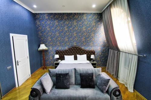 a blue bedroom with a bed and a couch at Prime Boutique Hotel in Baku