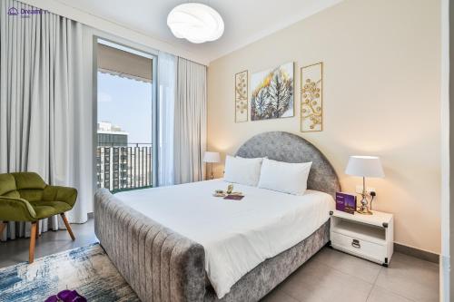 a bedroom with a large bed and a green chair at Dream Inn Apartments - Dubai Creek Harbour in Dubai