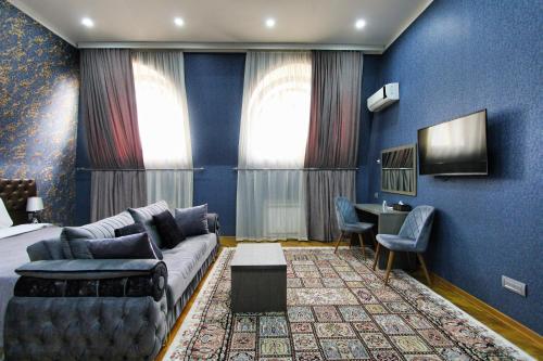 a bedroom with a couch and a bed and a desk at Prime Boutique Hotel in Baku