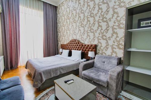 a hotel room with a bed and a chair at Prime Boutique Hotel in Baku