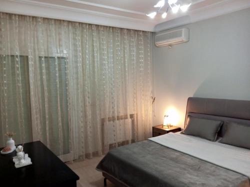 a bedroom with a bed and a window with curtains at LE REFUGE DU CHARME votre maison loin de chez vous in Akouda