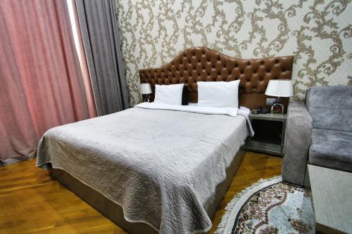 a bedroom with a large bed and a chair at Prime Boutique Hotel in Baku