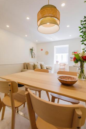 a dining room and living room with a wooden table and chairs at Casa dos Relevos - Centro Histórico de Santarém in Santarém