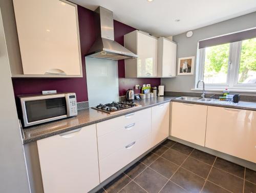 a kitchen with white cabinets and a microwave at Chilton Charm in Chilton