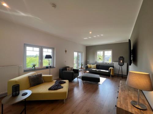 un soggiorno con un divano e delle sedie gialle di Braunlage Lodge a Braunlage