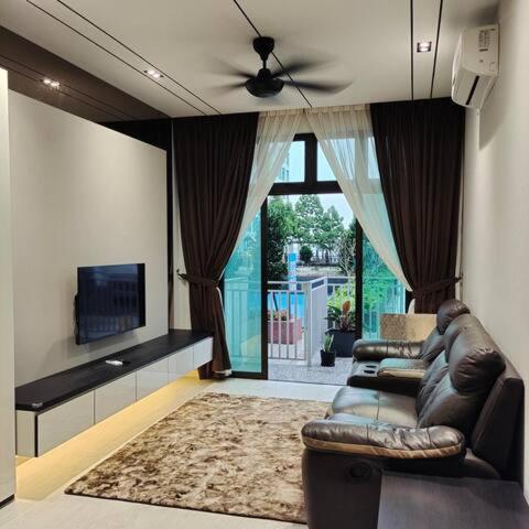 a living room with two leather couches and a television at D'summit by Comfort Places Management in Johor Bahru
