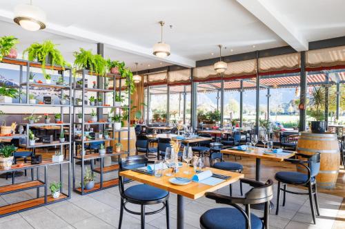 ein Restaurant mit Tischen und Stühlen und großen Fenstern in der Unterkunft Hapimag Ferienwohnungen Interlaken in Interlaken
