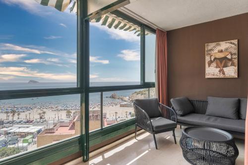 a living room with a large window with a view of the beach at Sea View of Benidorm in Cala de Finestrat