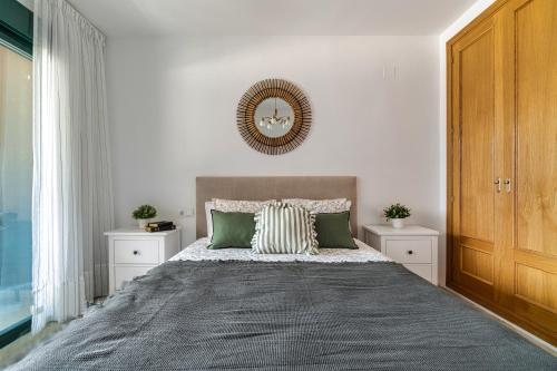 a bedroom with a large bed with green pillows at Sea View of Benidorm in Cala de Finestrat