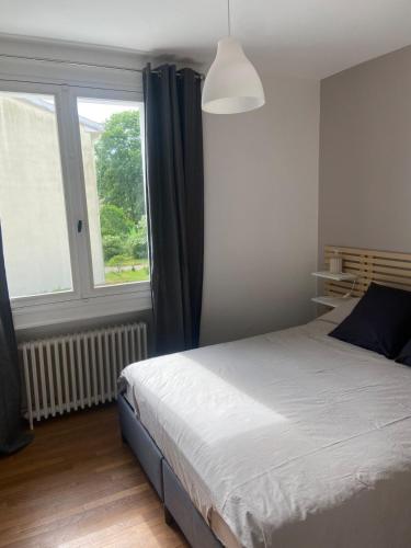 ein Schlafzimmer mit einem Bett und einem großen Fenster in der Unterkunft Gite de la Plaine in Cubjac