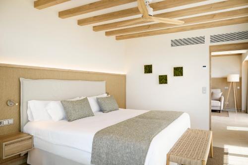 a bedroom with a large white bed and wooden ceilings at Iberostar Selection Es Trenc -New Opening- in Colonia Sant Jordi