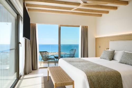 a bedroom with a bed and a view of the ocean at Iberostar Selection Es Trenc -New Opening- in Colonia Sant Jordi