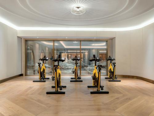a gym with a row of exercise bikes in a room at Raffles London at The OWO in London