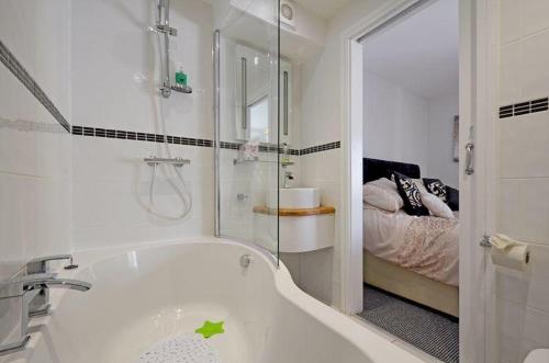 a white bathroom with a tub and a bed at Foxwood in Kenwyn