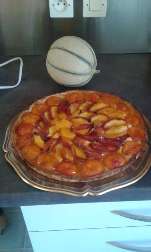a fruit pie sitting on a counter with a melon at La Gerbaudiere Chambres&Table d hotes proche Mont Saint Michel CUISINE MAISON in Notre-Dame-du-Touchet