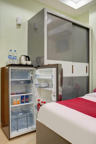 a small kitchen with an open refrigerator at Hotel Durbar By Vardaan Residency in Gurgaon