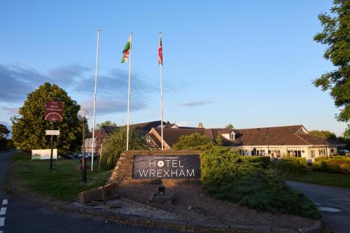 a hotel wrexham sign with two flags on top of it at Hotel Wrexham in Wrexham