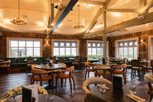 a restaurant with tables and chairs and windows at Hotel Wrexham in Wrexham