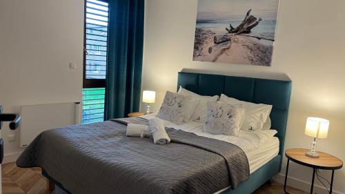 a bedroom with a bed with a blue head board at Apartamenty Belni Hel Edyta i Maciej Wolak in Hel