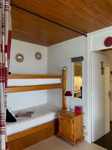 une chambre avec deux lits superposés et une table dans l'établissement Appartement cosy à Chamrousse avec vue sur montagne + 34m²., à Chamrousse