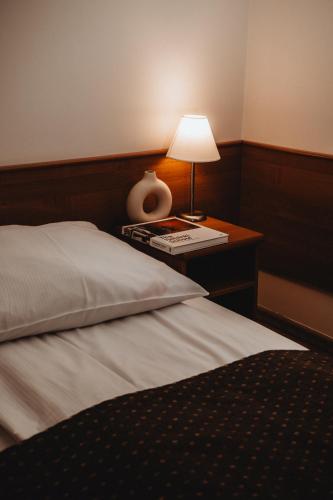a bedroom with a bed and a table with a lamp at Pensjonat Witoldówka in Krynica Zdrój
