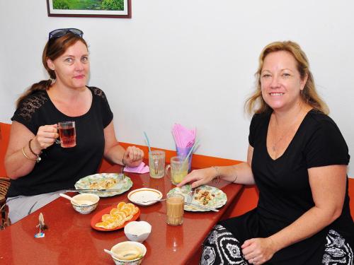 two women sitting at a table eating food at Sajhome Fortkochi, Kochi, Kerala, inda in Cochin