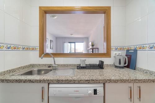 a kitchen counter with a sink and a mirror at Sea View of Benidorm in Cala de Finestrat