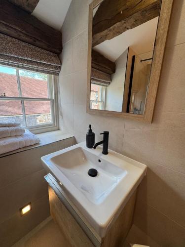 a bathroom with a sink and a mirror at The Menagerie in Towcester