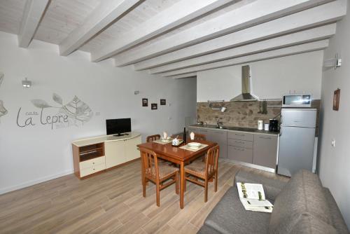 a living room with a table and a kitchen at Appartamenti Fossato in Tremosine Sul Garda